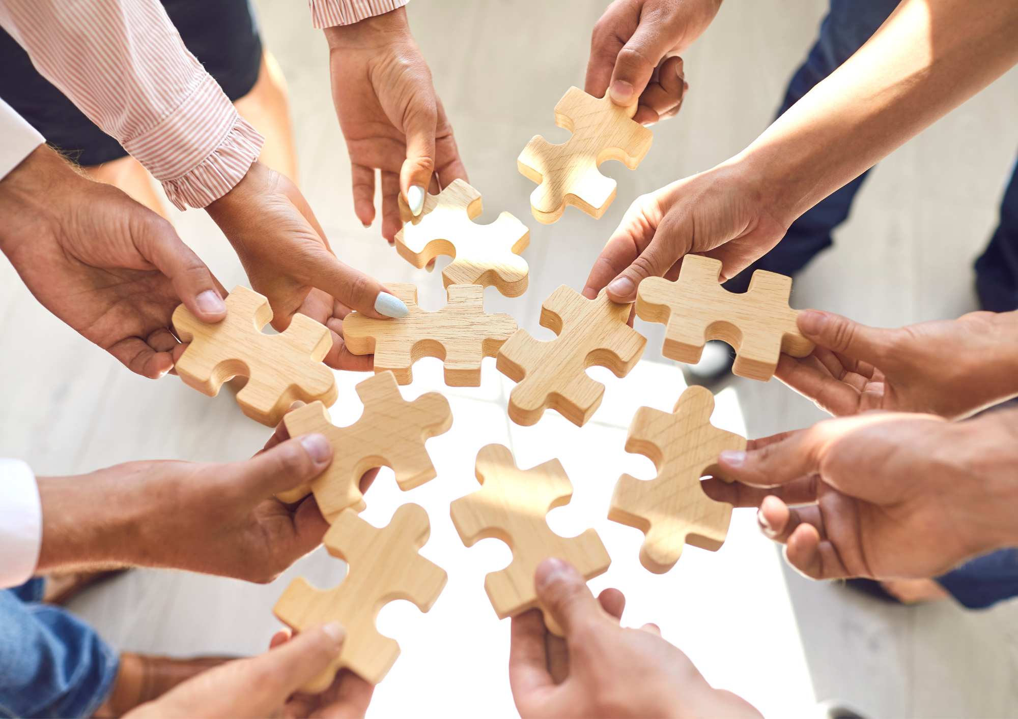Équipe collaborant, mains assemblant les pièces d'un puzzle